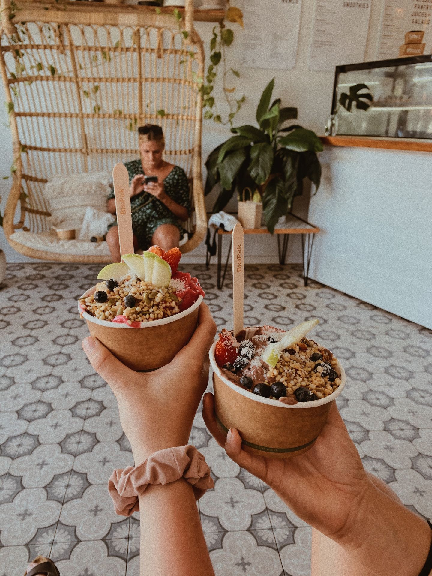 woman in black and white floral dress holding brown ceramic bowl with food